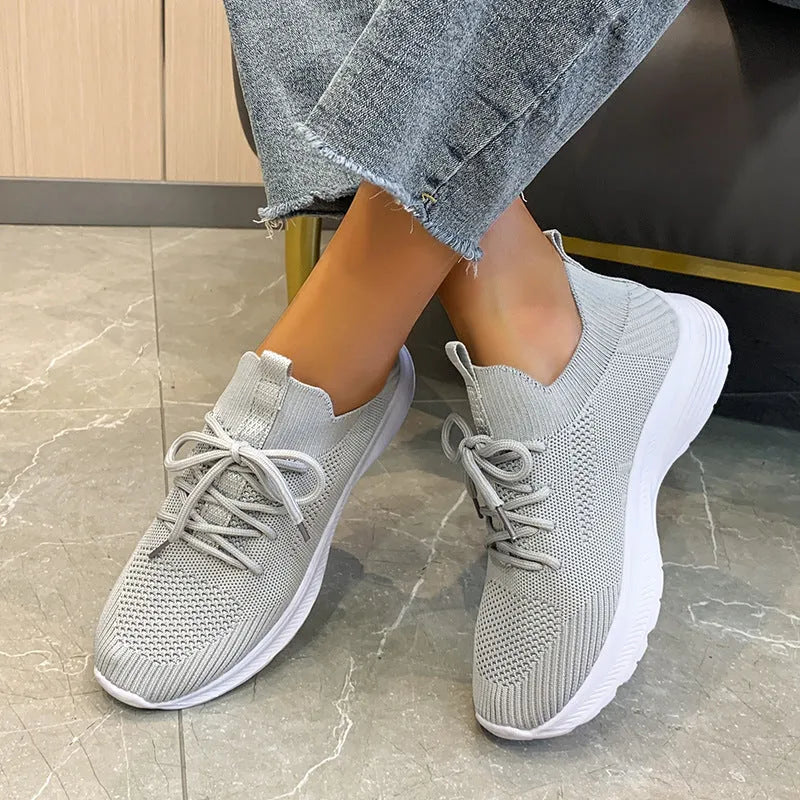 Women's mesh running shoes in creamy white with Flyknit upper and rubber sole