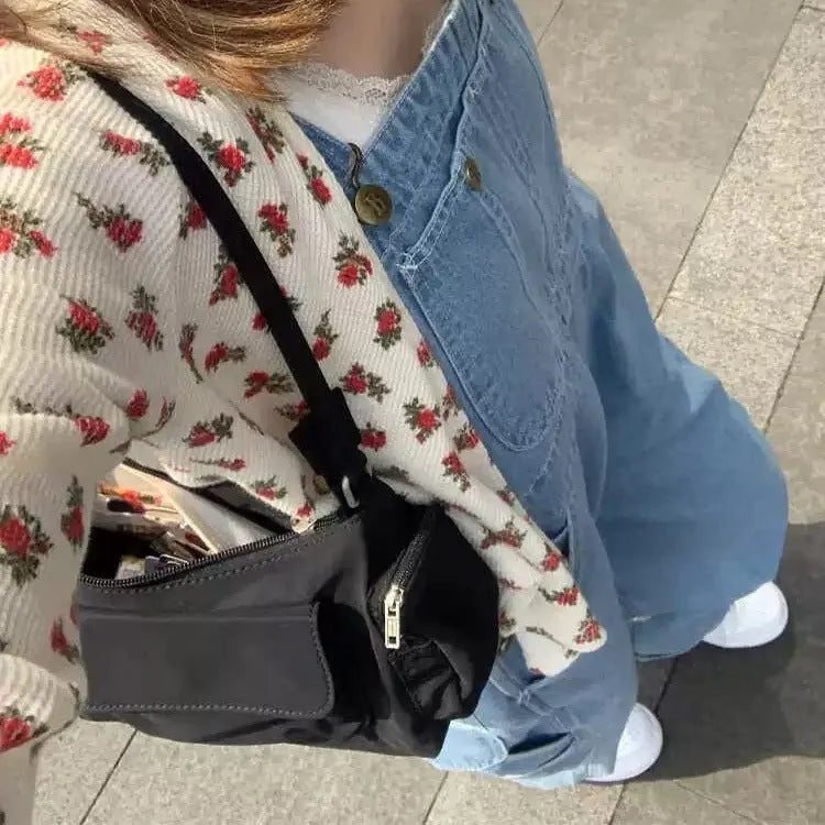 Black nylon shoulder bag with double pockets and side line detail, showing compact dimensions