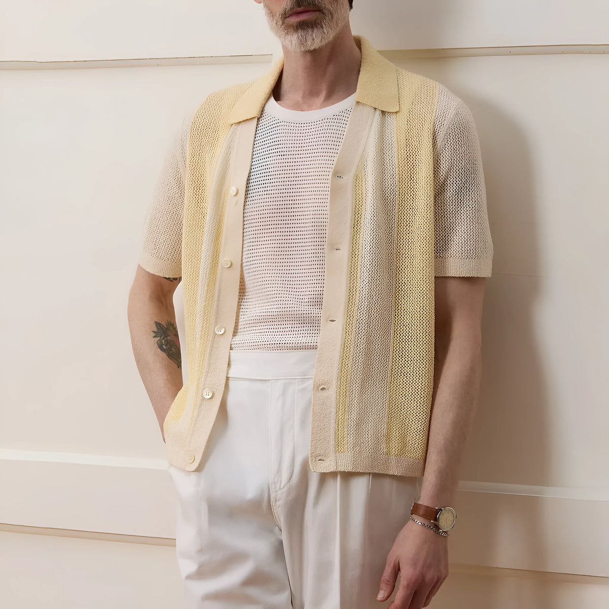 A bright yellow men's short-sleeved polo shirt with hollow-out asymmetric patterning on a casual model.