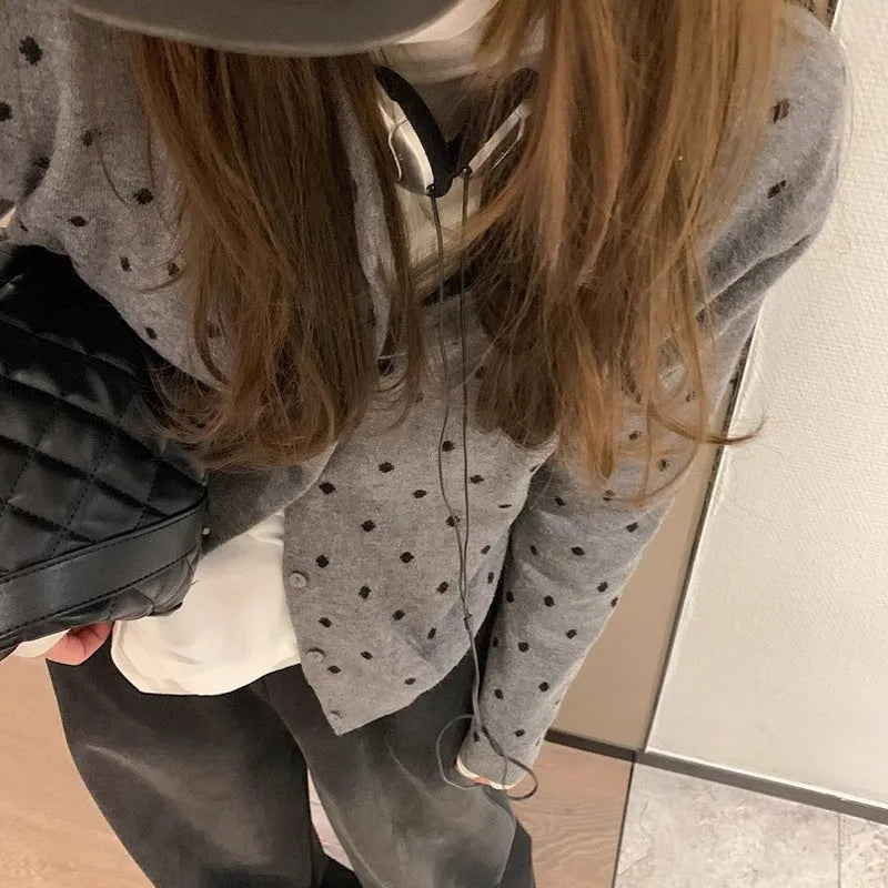 Women's loose fit grey dot knitted cardigan with crocheted flower trim on long sleeves.