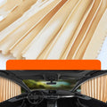 Retractable car sun curtain extended across windscreen with roller shutter mechanism visible.