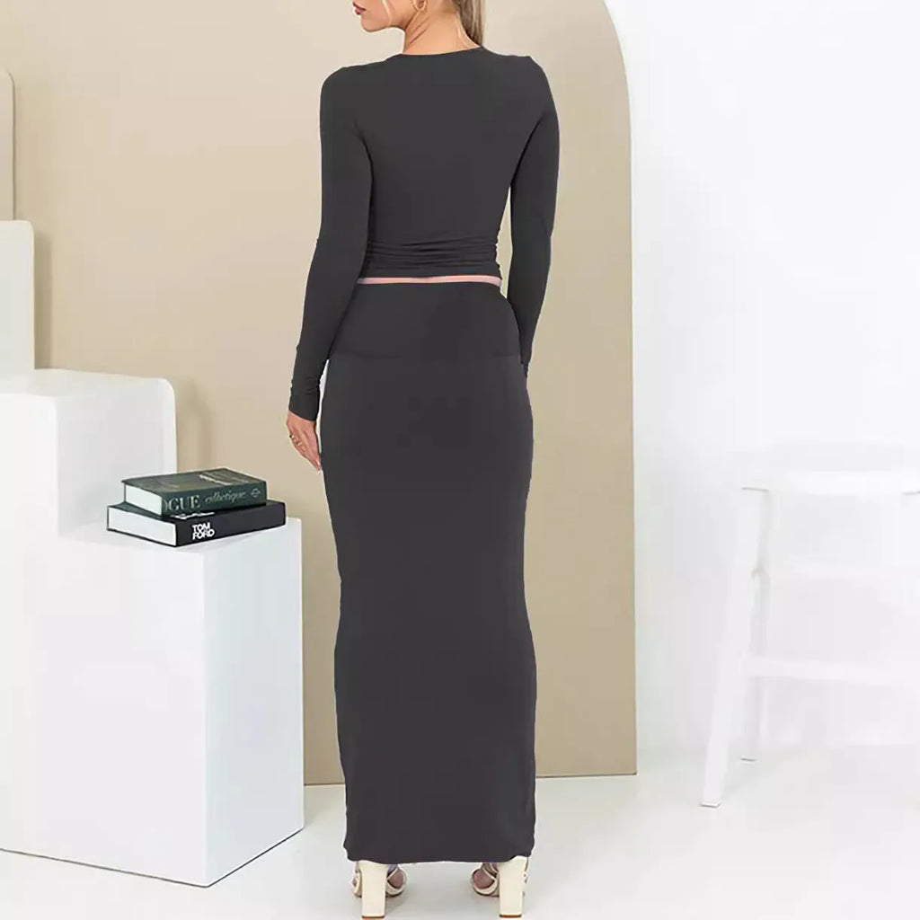 Women's black polyester two-piece suit with exposed navel top and long skirt.