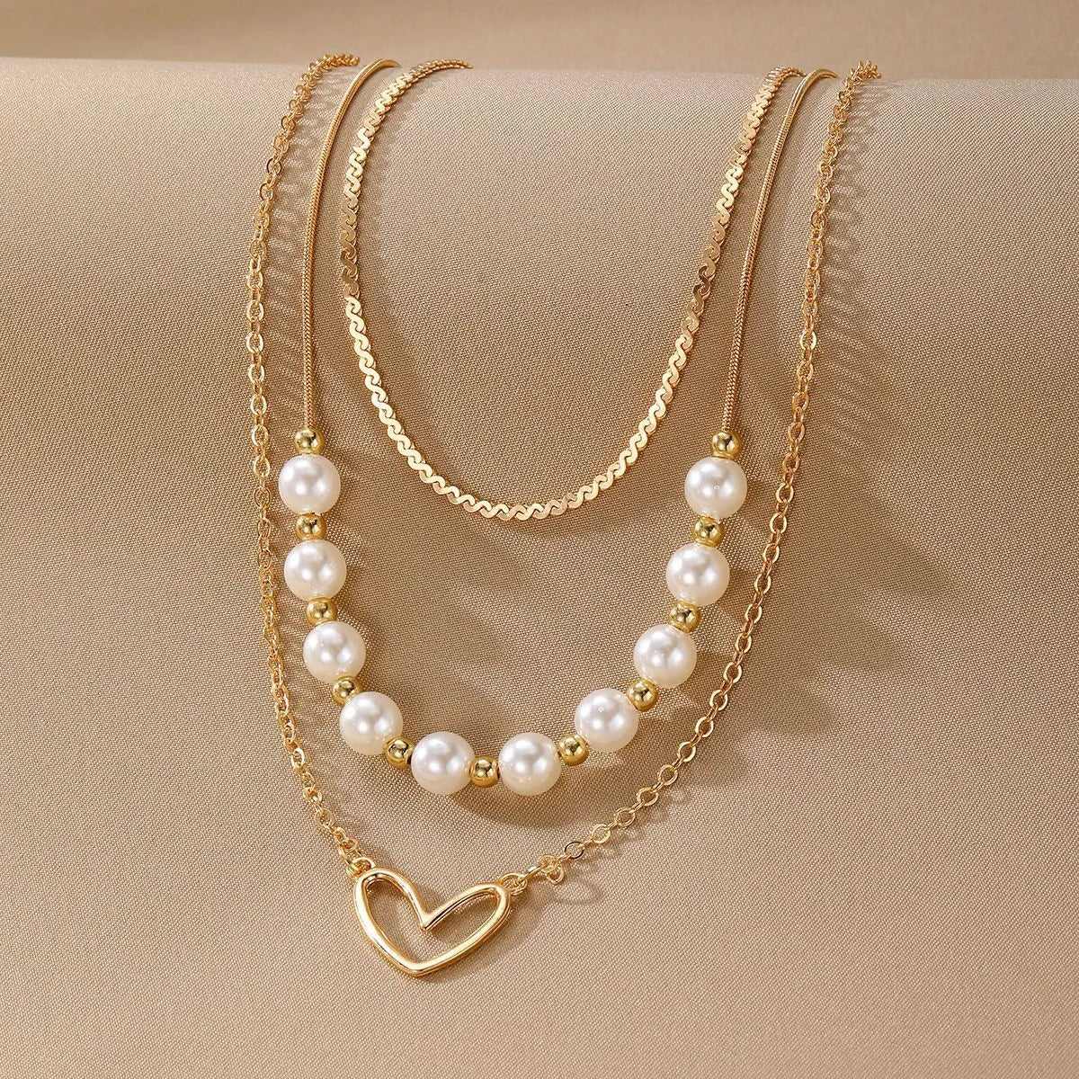 Vintage gold necklace with double heart pendant on textured pearl chain