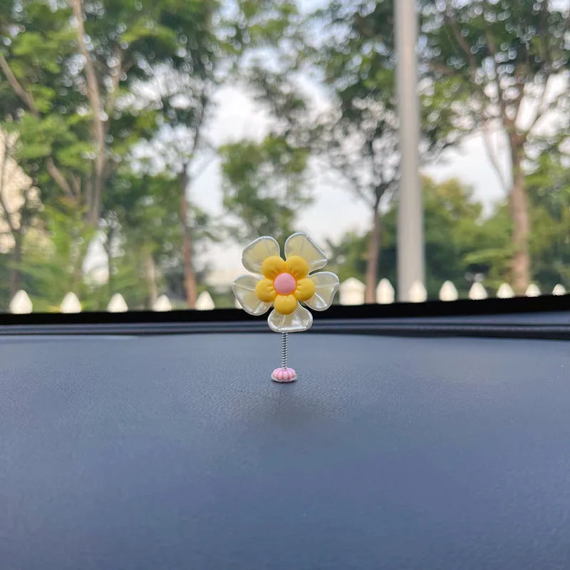 Small colourful plastic swing car decoration in blue, green, pink, purple, and yellow options.