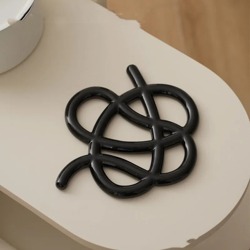 Ceramic heat proof mat in an irregular shape on a kitchen countertop.
