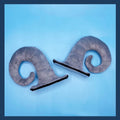 A pair of composite fibre demon horn ornaments for a motorcycle helmet in black, pink, brown, or grey.