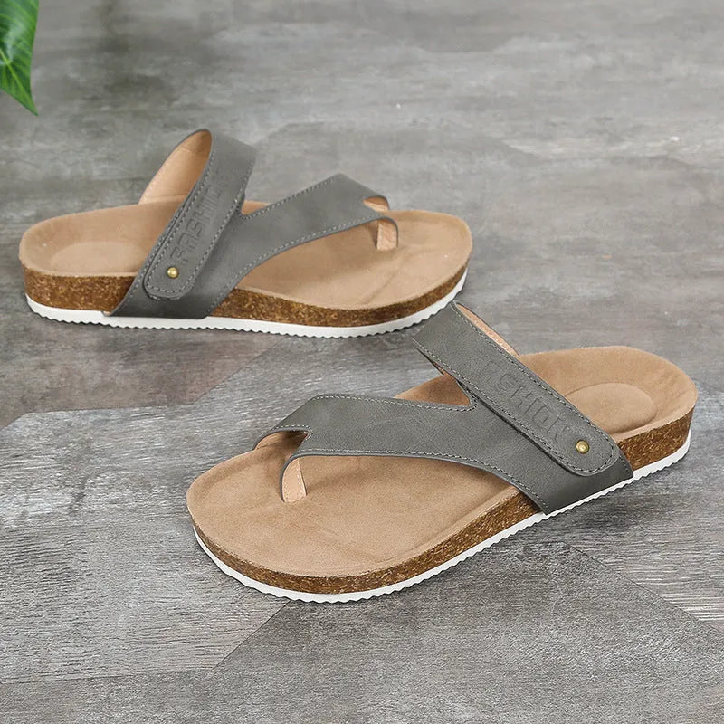 Flat toe ring flip-flops in blue with a thick foam sole on a wooden floor.