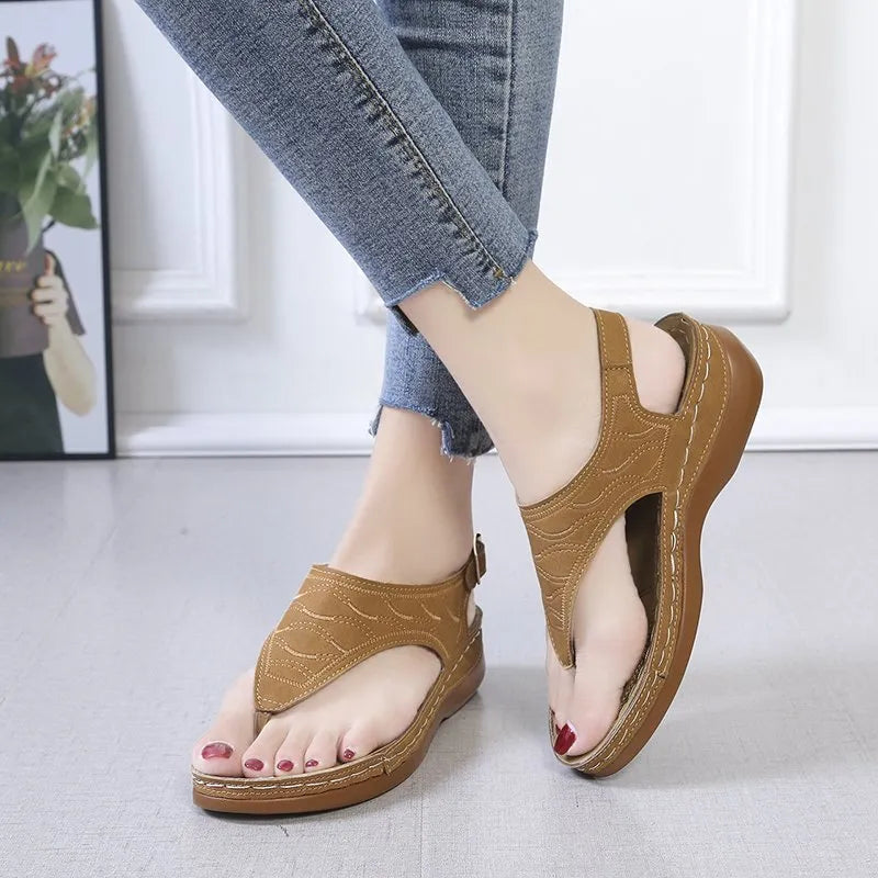 Women's black wedge heel sandals with an adjustable back strap buckle on a white background.