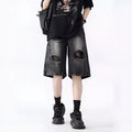 Man wearing black washed ripped denim shorts in a loose, retro style