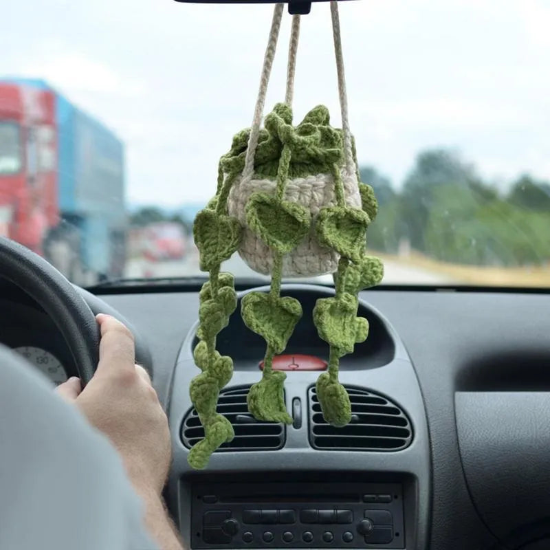Green and white knitted wool car plant decoration basket with white hanging cord.