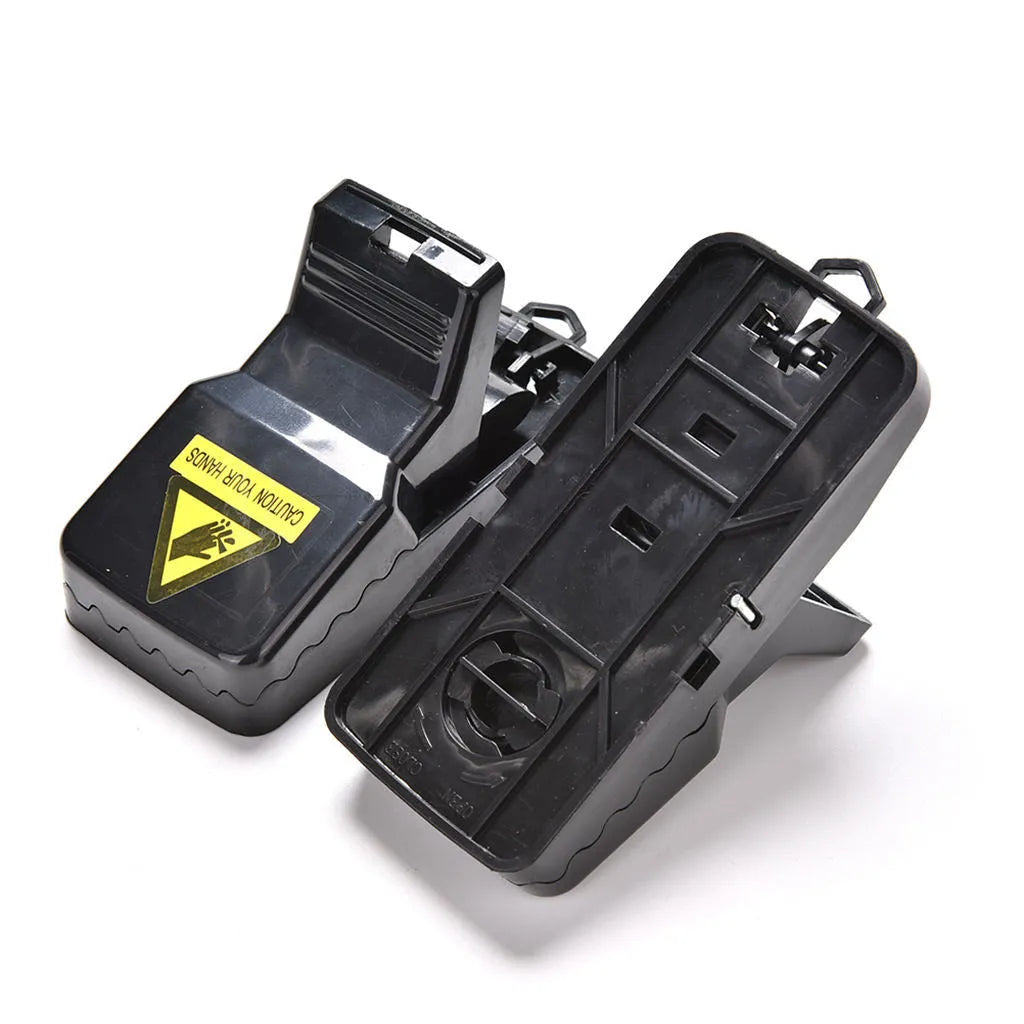 Six black plastic snapping mousetraps showing size and smooth surface.