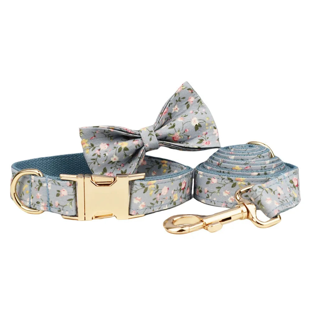 Blue floral patterned dog collar with matching accessories including leash, bow, vest, and poop bag