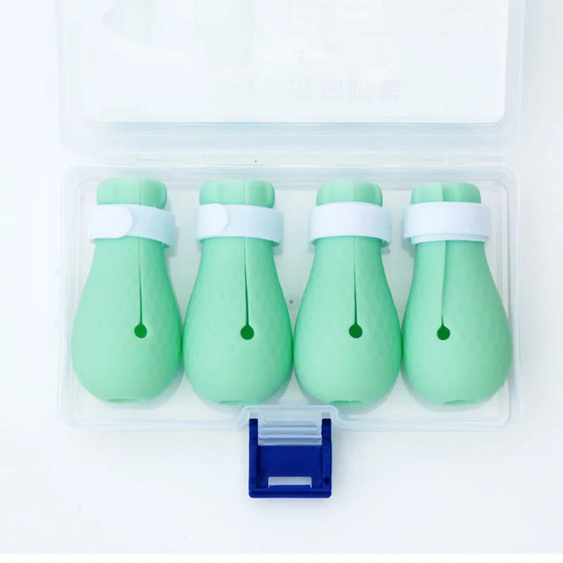 Four green silicone foot covers for protecting hands from cat scratches during pet care.