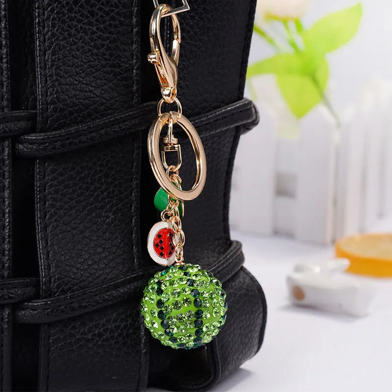 Green watermelon shaped zinc alloy keychain measuring 12cm in length