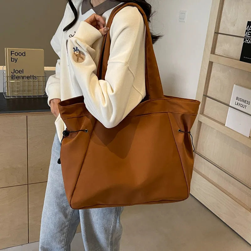 Soft Oxford cloth folding tote bag shown in a choice of five colours on a plain background.
