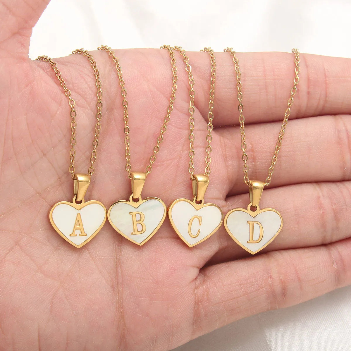 Gold-plated stainless steel necklace with a letter pendant and heart charm on a 45+5cm chain.