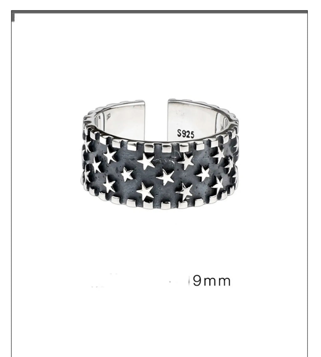 Adjustable sterling silver ring with a geometric pattern of five pointed stars on the band.