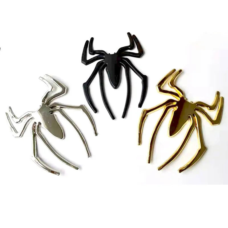 Three-dimensional metal spider bumper sticker in gold finish, measuring 7cm by 5cm.