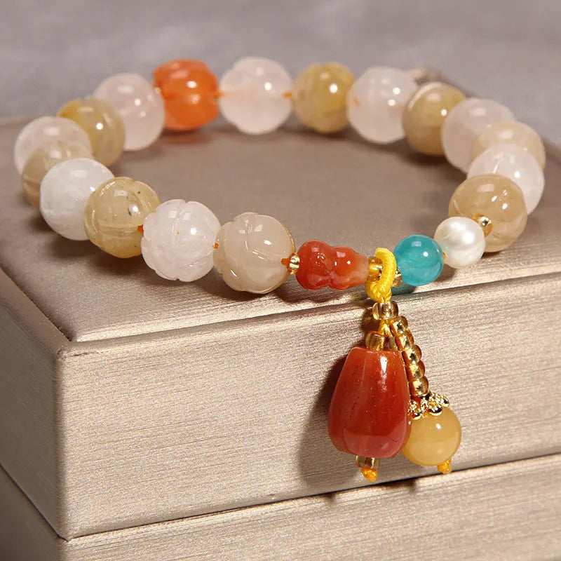 Adjustable khaki bracelet with large yellow agate bead on gold silk cord.