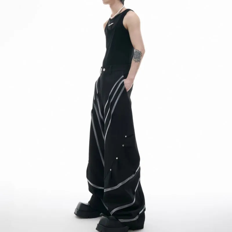 Men's black trousers with silver metal striped rivet details and pleated front.