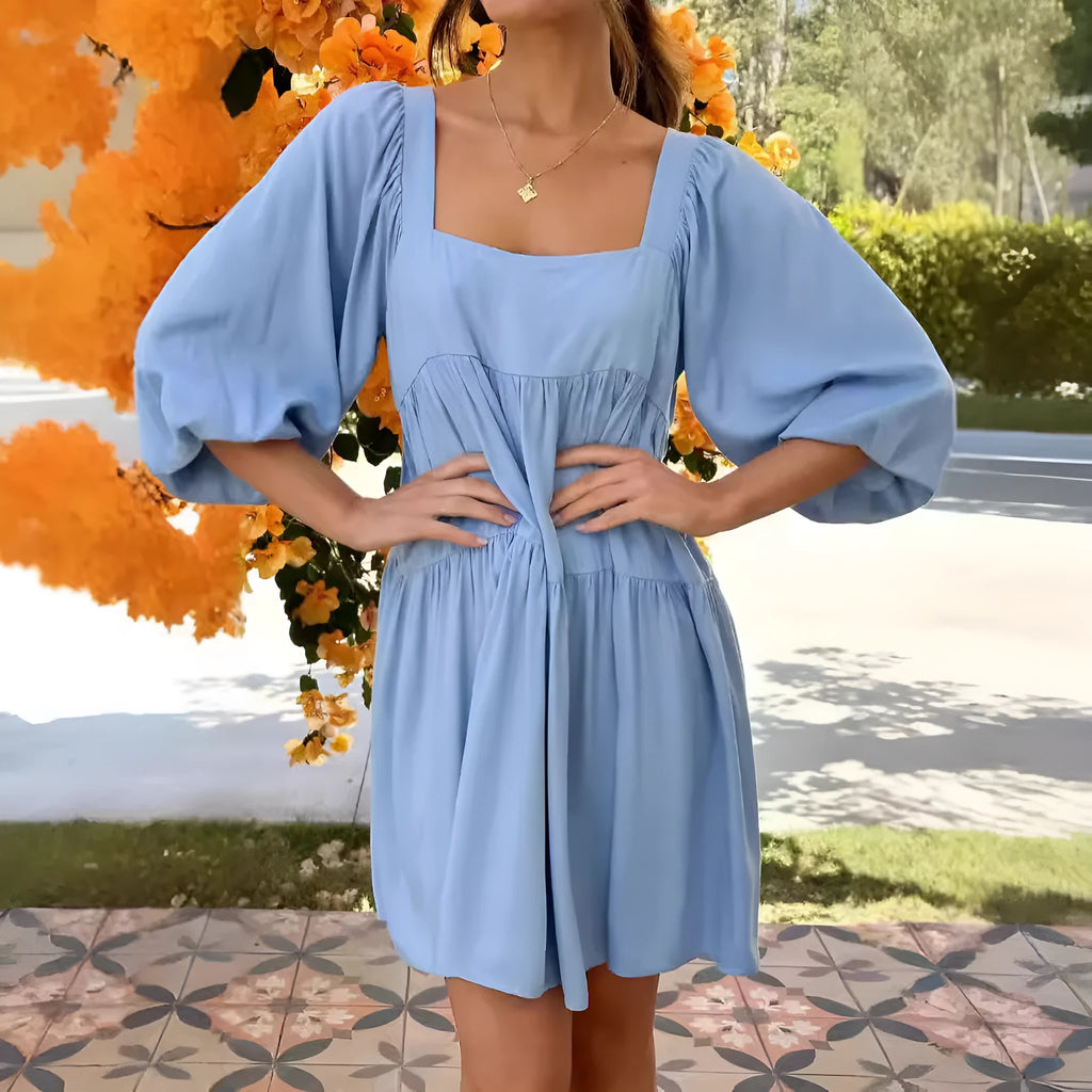 Girls orange backless dress with puff sleeves and a square collar, showing A-line skirt.
