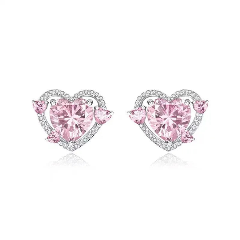 A pair of white heart-shaped stud earrings for women on a plain background.