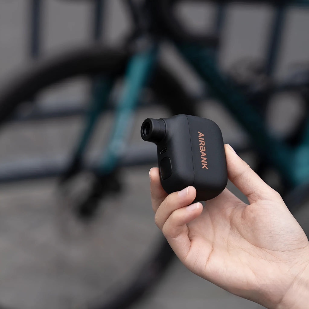 Black mini electric bike pump with USB charging cable and waterproof storage bag for portable bicycle tyre inflation