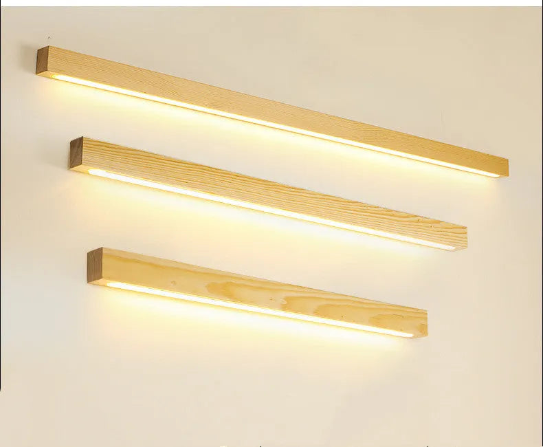 Modern walnut-colour wood log strip wall lamp with integrated LED lighting mounted on a wall.