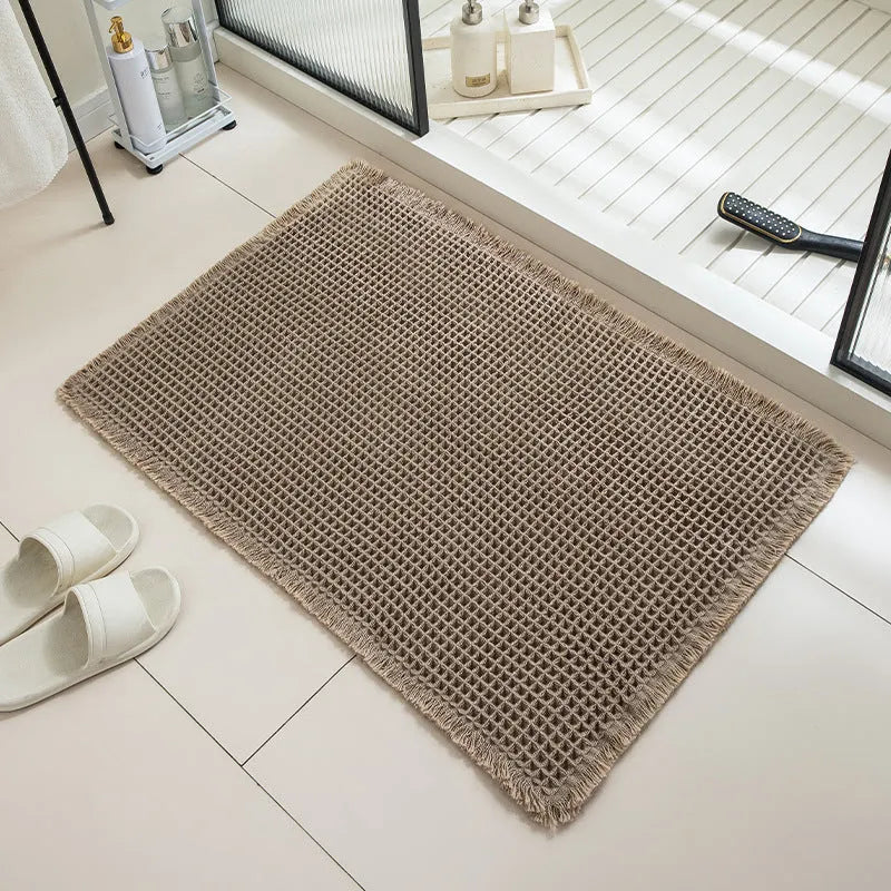 A checkered pattern non-slip polyester bathroom floor carpet shown in a beige colour.