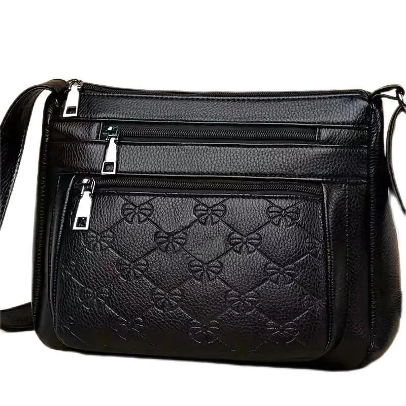Black women's crossbody bag with embossed butterfly pattern showing phone pocket and external slit
