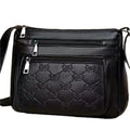 Black women's crossbody bag with embossed butterfly pattern showing phone pocket and external slit