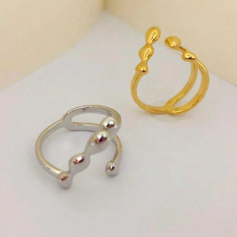 Brass opening ring with spherical elements in gold or silver finish