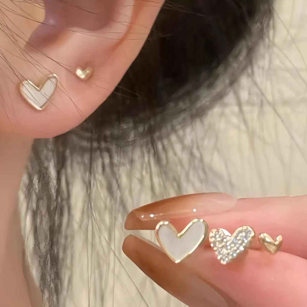 Women's three-pair heart-shaped love earrings set in gold, black, and pink colours with sweet girly style