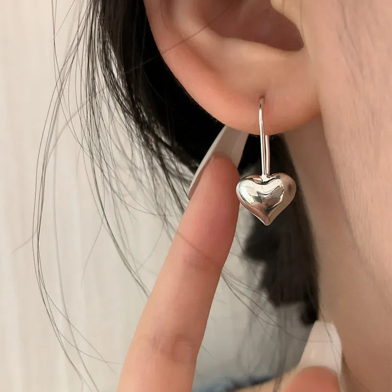 Three-dimensional copper heart earrings with glossy finish and Korean-style design