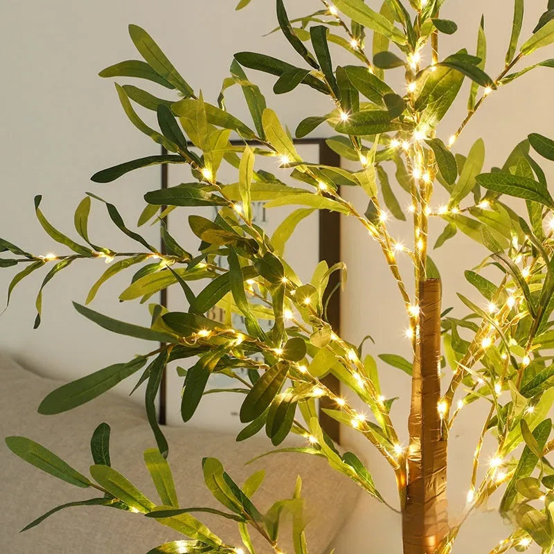 1.8 metre tall artificial olive leaf tree lamp with warm white LED lights illuminated in garden setting