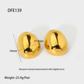A pair of geometric gold-coloured ear studs with a glazed finish and exaggerated line details on a white background.
