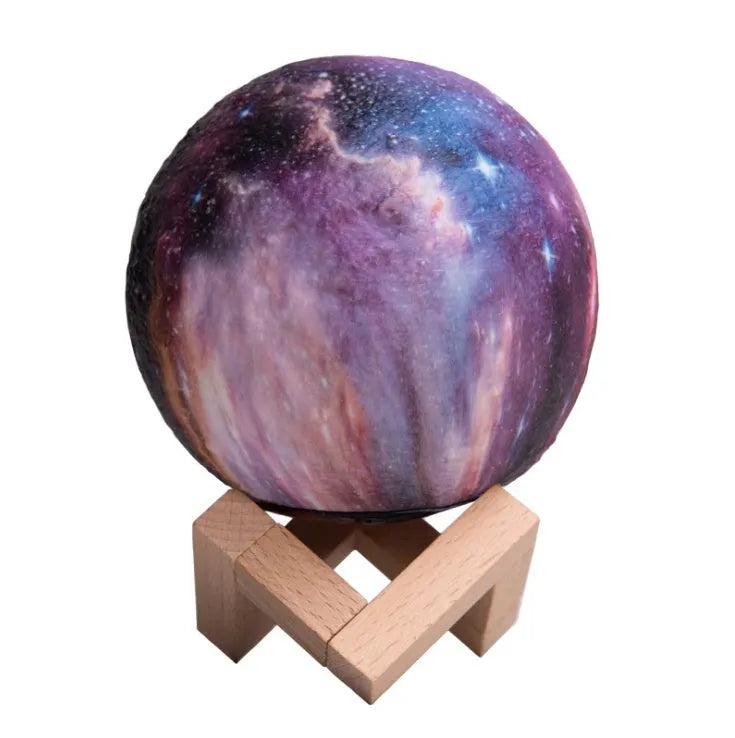 White spherical lunar night light with textured surface and soft LED glow on a dark surface.