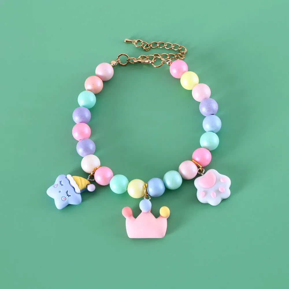 Colourful macaron-themed resin pet collar and matching bracelet set on a table.