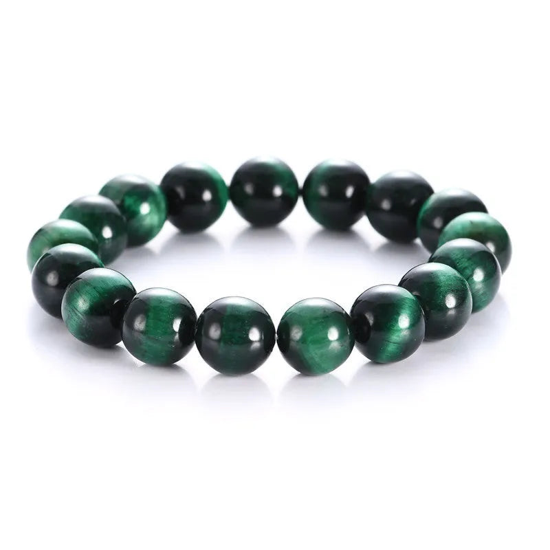 Green tiger eye stone bracelet with polished geometry beads on a wrist, showing the stone's natural banding.
