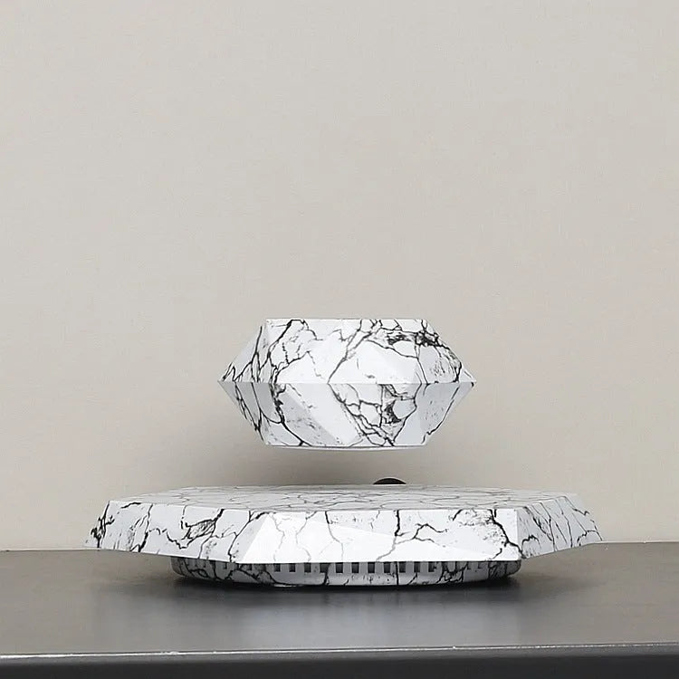 Magnetic levitating marble-colour plant pot floating above base with small plant