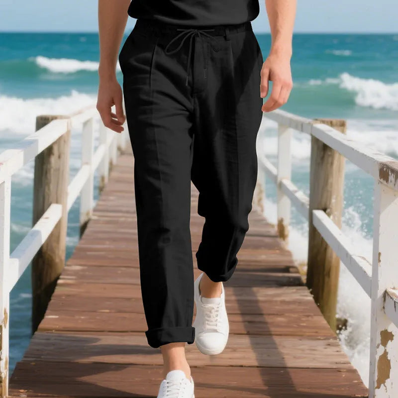 Men's loose-fit linen trousers in light khaki colour with a drawstring waistband.