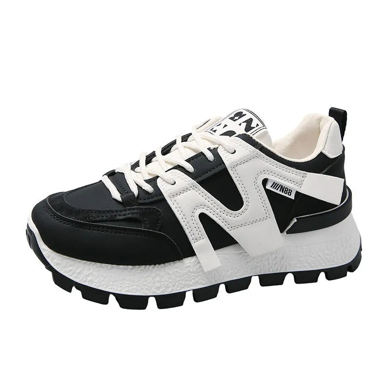 Pair of low-top unisex casual sneakers in black or white with round toe and front lace-up closure.
