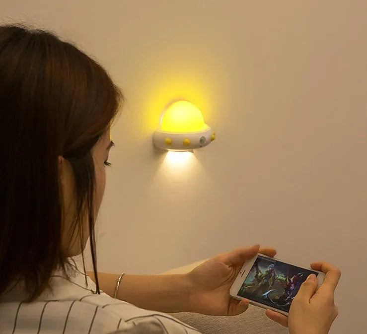 Remote control UFO shaped bedside night light in blue, pink, or white colour options.