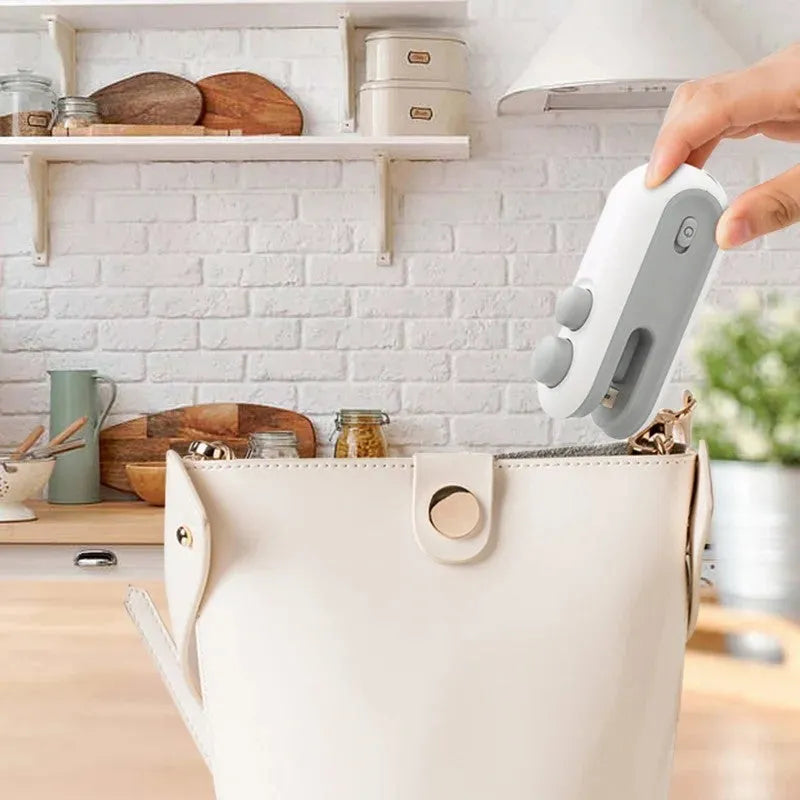 Handheld white vacuum sealer with cutter blade and magnetic back for bag sealing
