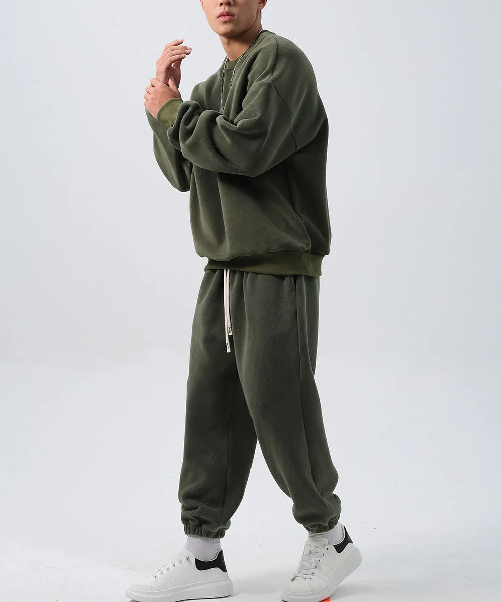 Men's polar fleece sports suit showing loose long sleeve coat and padded trousers in army green.