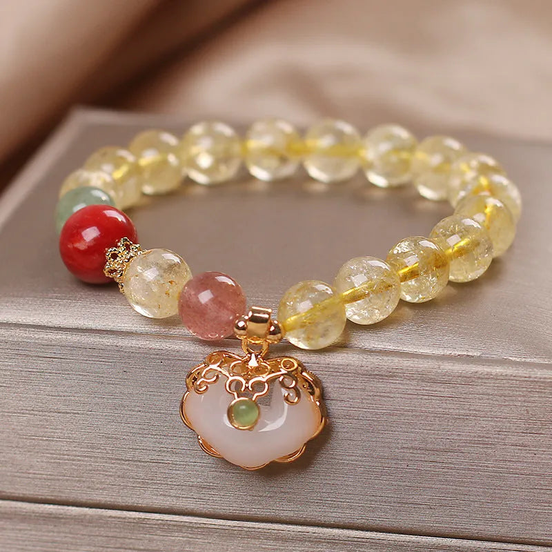Women's yellow alloy bracelet with a ruyi pendant charm holding natural citrine and yellow hair crystal jade.