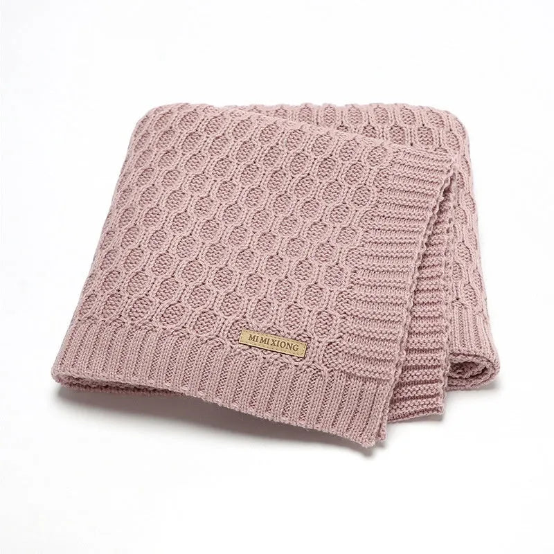 Infant hug blanket with three-dimensional lines pattern in a solid colour, measuring 70 by 90 centimetres.