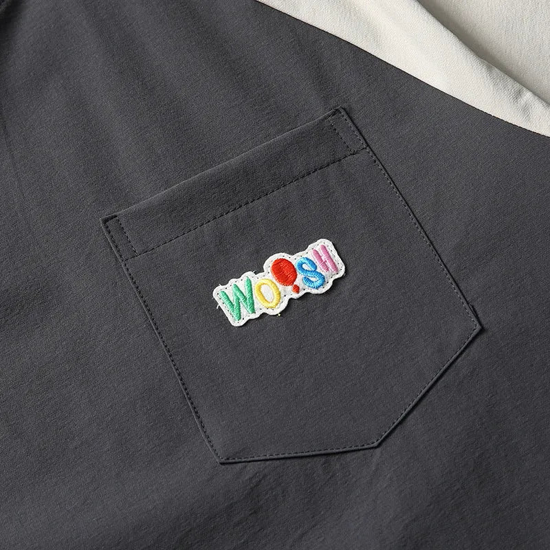 Dark grey men's loose fit T-shirt with contrast colour raglan sleeves on a hanger.