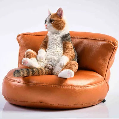 Small resin ornament of a cat sleeping on a sofa for car dashboard or shelf decoration.