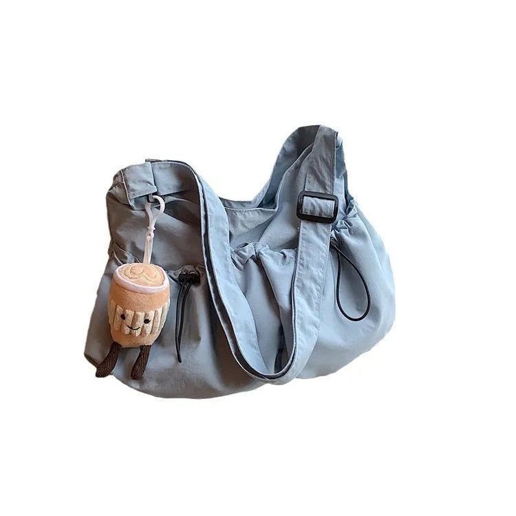 Green ultra-light pleated crossbody bag showing split pocket design and compact 35cm dimensions